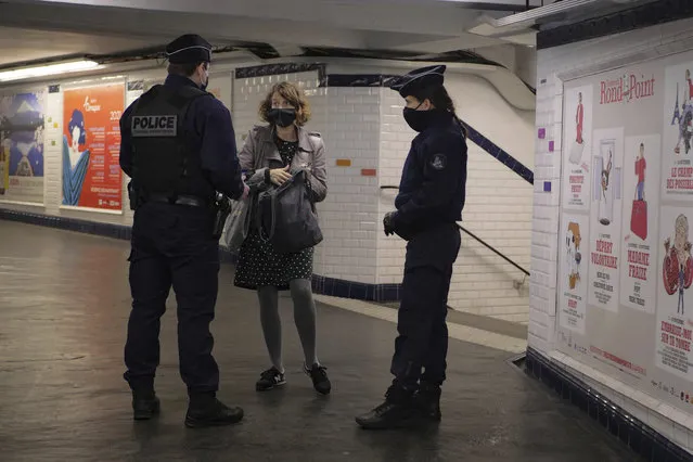 Policemen controls a commuters in the Paris subway, Friday, October 30, 2020. France re-imposed a monthlong nationwide lockdown Friday aimed at slowing the spread of the virus, closing all non-essential business and forbidding people from going beyond one kilometer from their homes except to go to school or a few other essential reasons. (Photo by Thibault Camus/AP Photo)
