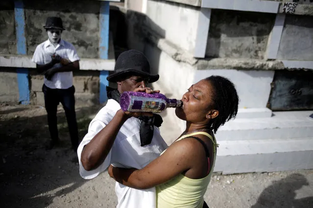 A woman drinks from a bottle during Voodoo celebrations at a cemetery in Port-au-Prince, Haiti, November 1, 2020. (Photo by Andres Martinez Casares/Reuters)