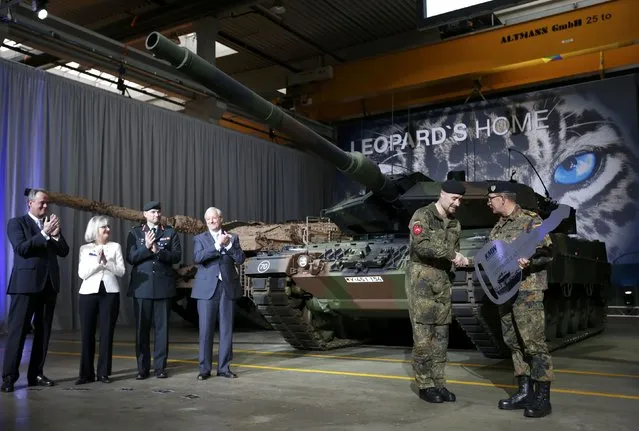 German General Rainer Korff (R) hands over a symbolic key to Master Sergeant Sascha Sieson during the official handover of the new tank Leopard 2A7 by defence industry company Krauss-Maffei Wegmann (KMW) to the German armed forces Bundeswehr in Munich December 10, 2014. (Photo by Michaela Rehle/Reuters)