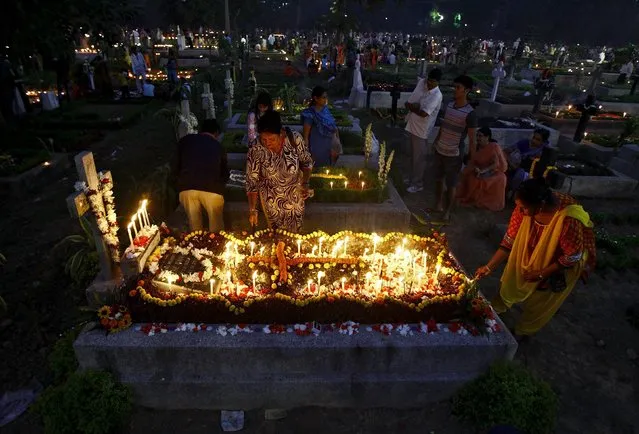 People burn incense sticks and light candles as they pray beside the graves of their relatives at a cemetery during the observance of All Souls Day in Kolkata November 2, 2015. (Photo by Rupak De Chowdhuri/Reuters)