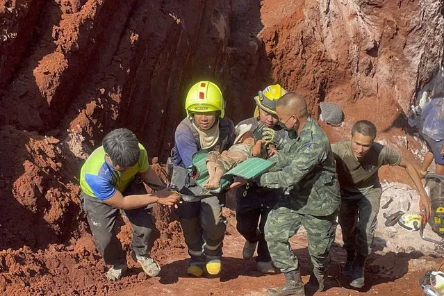Following an overnight emergency operation, rescue workers and military carry a 1 year-old from a deep hole in the northern Thailand province of Tak, 420 kms. (260 miles) north of Bangkok, Tuesday, February 7, 2023. The toddler, who is from Myanmar, fell into the 15 meter deep hole used for groundwater pipes yesterday evening. (Photo by Chiravuth Rungjamratratsami/AP Photo)