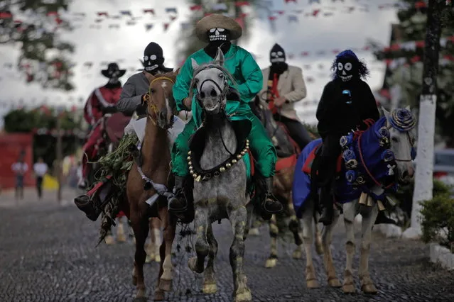 Masked men ride in a morning procession as part of the “Cavalhadas” festival in Pirenopolis, Brazil, Sunday, May 19, 2013. The popular festival is a tradition that was introduced in the 1800's by a Portuguese priest to mark the the ascension of Christ. The 3-day festival reenacts the Christian knights' medieval defeat of the Moors. (Photo by Eraldo Peres/AP Photo)