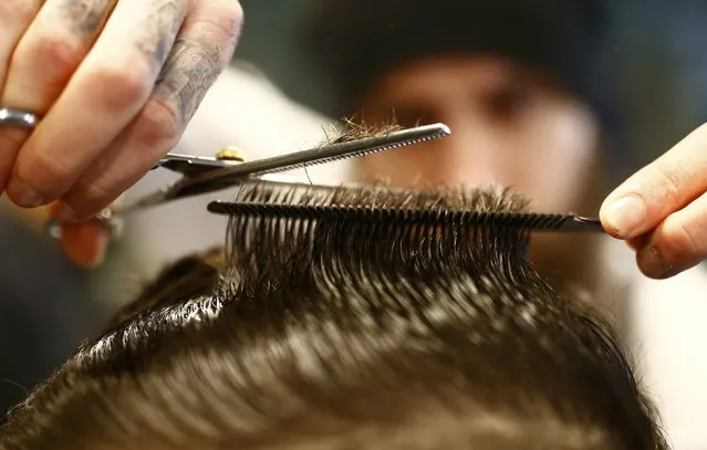 Alex “Torreto” Vellios, a 26-year old Greek-born barber concentrates while styling the hair of a customer at his Torreto barber shop in Frankfurt January 6, 2015. (Photo by Kai Pfaffenbach/Reuters)