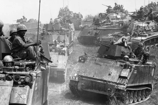 Tanks and armored personnel carriers of the Fifth Mechanized Division churn up turf as they leave an encampment just south of the demilitarized zone in South Vietnam on April 25, 1969, showing evidence of the damage inflicted during the night by North Vietnamese engineers. Thirteen GIs were killed, 24 were wounded and seven vehicles were damaged or destroyed when the North Vietnamese hit the encampment in the night, carrying Bangalore torpedoes. (Photo by Robert Ohman/AP Photo)