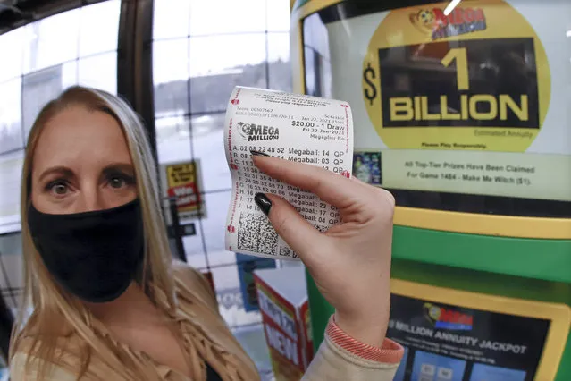 A patron, who did not want to give her name, shows the ticket she had just purchased for the Mega Millions lottery drawing at the lottery ticket vending kiosk in a Smoker Friendly store, Friday, January 22, 2021, in Cranberry Township, Pa. The jackpot for the Mega Millions lottery game has grown to $1 billion ahead of Friday night's drawing after more than four months without a winner. (Photo by Keith Srakocic/AP Photo)