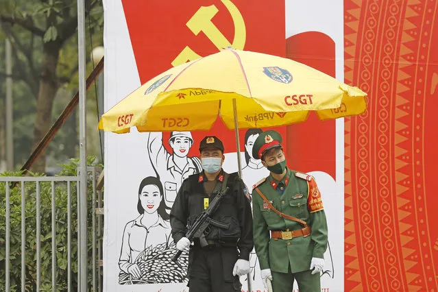 Vietnamese policemen wearing face masks stand guard outside the National Convention Center in Hanoi, Vietnam, Tuesday, January 26, 2021. Vietnam's ruling Communist Party began a crucial week-long meeting in the capital Hanoi to set the nation's path for the next five years and appoint the country's top leaders. (Photo by Minh Hoang/AP Photo)