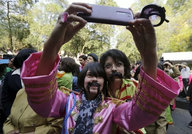 A woman dressed as a member of The Beatles takes a selfie during an attempt to set a Guinness World Record of the largest number of people dressed as The Beatles, at a park in Mexico City, Mexico November 28, 2015. (Photo by Henry Romero/Reuters)