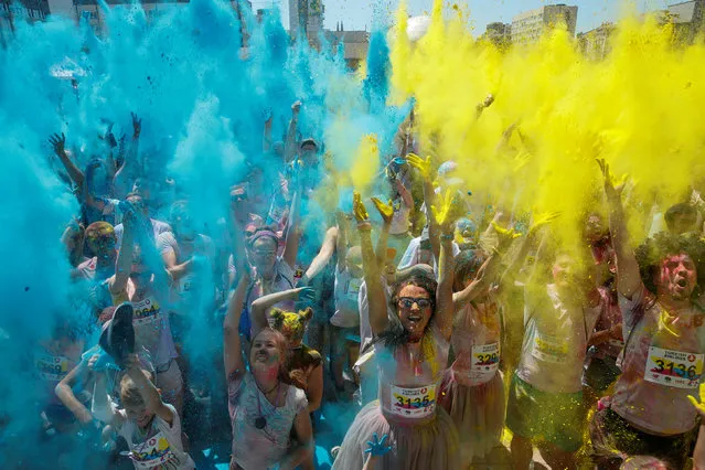 Paticipants throw coloured powder during the Colour Run in Kiev, Ukraine June 10, 2018. (Photo by Valentyn Ogirenko/Reuters)