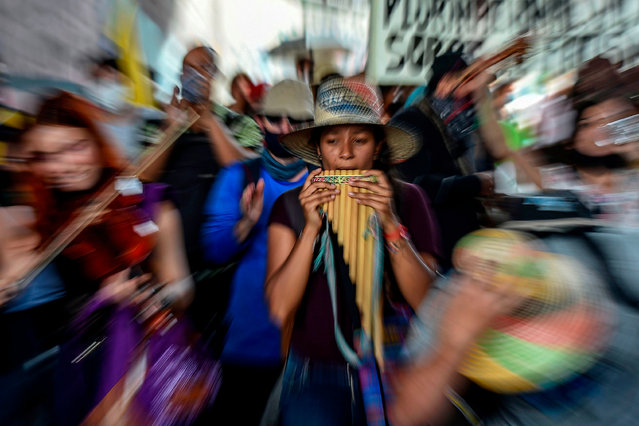 People paly music during a march in the framework of a national strike against the government of Colombian President President Ivan Duque, in Medellin, Colombia, on October 21, 2020. Indigenous people, teachers, students and union members marched in Colombia in a new day of protests. Indigenous groups from across the country arrived on Sunday in Bogota to demand a face-to-face meeting with the president on the rise in violence from guerrillas and other groups financed by drug trafficking (Photo by Joaquin Sarmiento/AFP Photo)