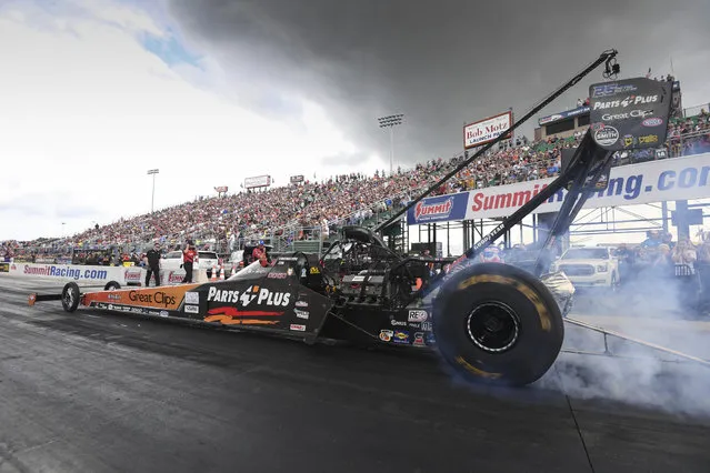 In this photo provided by the NHRA, Clay Millican does a burnout during Top Fuel qualifying Saturday, June 23, 2018, at the 12th annual Summit Racing Equipment NHRA Nationals drag races in Norwalk, Ohio. Millican used a 3.750-second pass at a track record 332.67 mph in the lone qualifying session of the day. (Photo by Jerry Foss/NHRA via AP Photo)