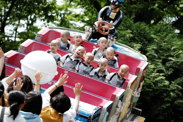Boys who are experiencing the lives of Buddhist monks by staying in a temple for three weeks as novice monks, enjoy a ride at Everland amusement park in Yongin, South Korea on May 17, 2023. (Photo by Kim Soo-hyeon/Reuters)