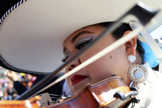 Daniela Orgin, plays her violin before a gathering to break the record of most mariachis performing in unison, at the Zocalo, Mexico City's main square, Sunday, November 10, 2024. (Photo by Ginnette Riquelme/AP Photo)