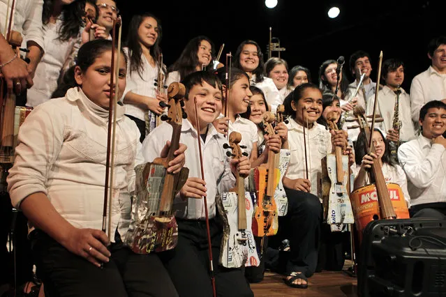 Members of the Orchestra of Recycled Instruments of Cateura pose for the audience during a concert in Asuncion, June 22, 2013. The orchestra is the brainchild of its conductor Favio Chavez, who wanted to help the children of garbage pickers at the local landfill, and the instruments are made from salvaged materials by craftsman Nicolas Gomez. (Photo by Jorge Adorno/Reuters)