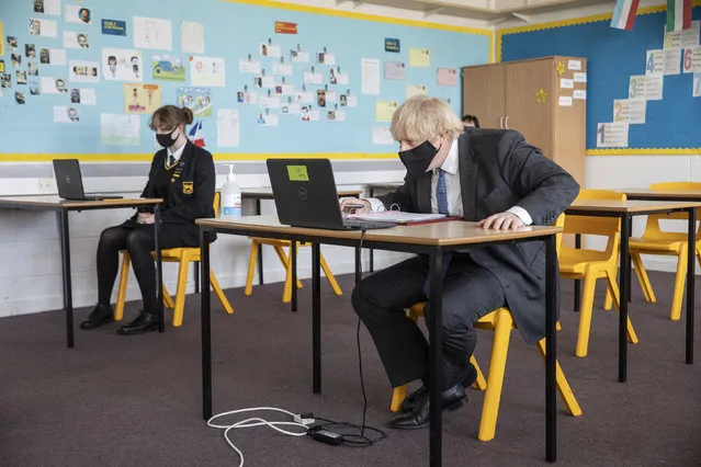 Britain's Prime Minister Boris Johnson takes part in an online class, during a visit to Sedgehill School in Lewisham, south east London, Tuesday, February 23, 2021, to see preparations for students returning to school.  Johnson has announced a gradual easing of one of Europe’s strictest lockdowns on, saying children will return to class and people will be able to meet a friend for coffee in a park in two weeks’ time. But people longing for a haircut, a restaurant meal or a pint in a pub have almost two months to wait, and people won’t be able to hug loved ones that they don’t live with until May at the earliest. (Photo by Jack Hill/Pool Photo via AP Photo)