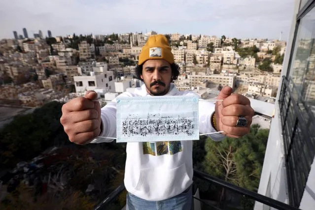 Jordanian artist and architect Saleh Mansour poses with his cityscape sketch on a mask to encourage people to wear them during the COVID-19 pandemic in Amman, Jordan on December 7, 2020. (Photo by Muhammad Hamed/Reuters)