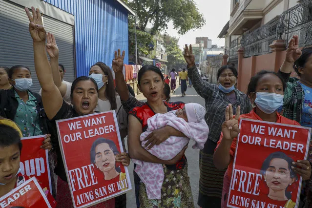 Demonstrators display pictures of deposed Myanmar leader Aung San Suu Kyi during a protest against the military coup in Mandalay, Myanmar, Wednesday, February 17, 2021. (Photo by AP Photo/Stringer)