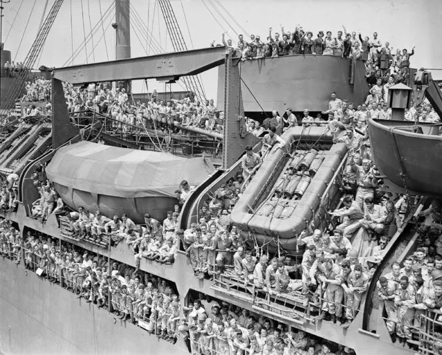 Docked at Pier 88 in Manhattan, New York City, these soldiers aboard the U.S.S. General Harry Taylor are celebrating their homecoming after World War II, on August 18, 1945. (Photo by AP Photo)