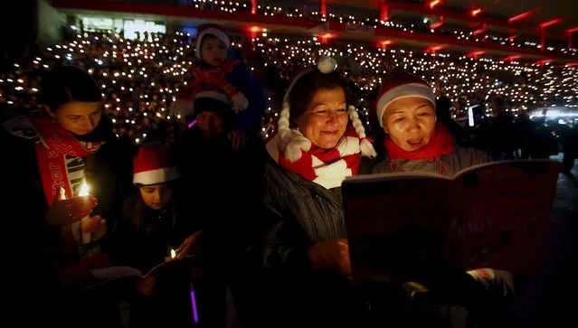 People attend the “Weihnachtssingen”, a candle-lit carol concert with 28000 fans of the second-division club FC Union Berlin at the Alte Foersterei stadium in Berlin, Germany, December 23, 2015. (Photo by Hannibal Hanschke/Reuters)