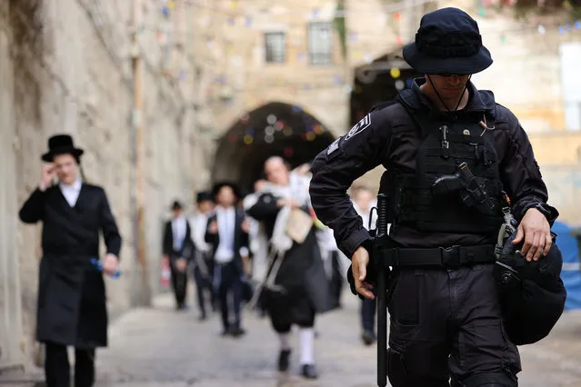 Jewish settlers escorted by Israeli forces enter Al-Aqsa Mosque compound after police drive out Palestinian worshippers following a morning prayer, in Jerusalem on April 18, 2022. Israeli forces also intervened in worshippers. On Sunday, more than 700 Israeli settlers forced their way into the Al-Aqsa Mosque complex under heavy police protection to celebrate the week-long Jewish Passover holiday, which started on Friday. (Photo by Mostafa Alkharouf/Anadolu Agency via Getty Images)