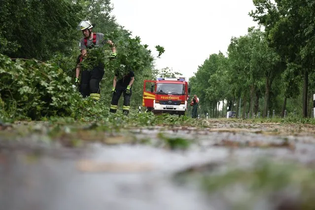 Fire fighters remove debris after a suspected tornado in Lippstadt, Germany, Friday, May 20, 2022. (Photo by Friso Gentsch/dpa via AP Photo)