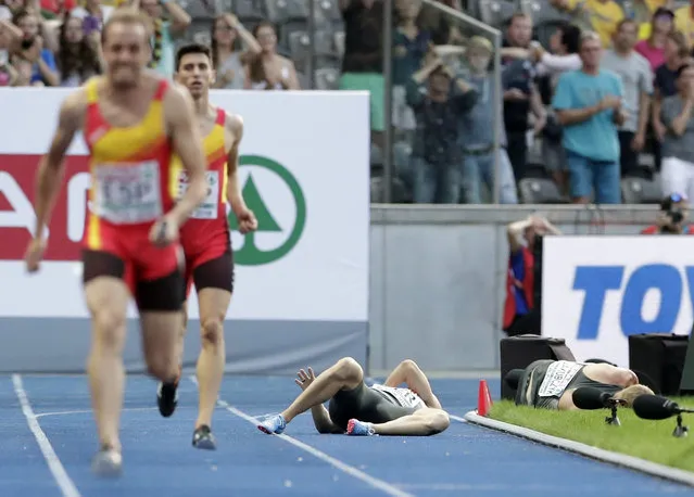 Germany's Lucas Jakubczyk, right, and Germany's Julian Reus, left, lie on the track after they collided during a men's 4 x 100 meter relay heat at the European Athletics Championships in Berlin, Germany, Sunday, August 12, 2018. (Photo by Michael Sohn/AP Photo)