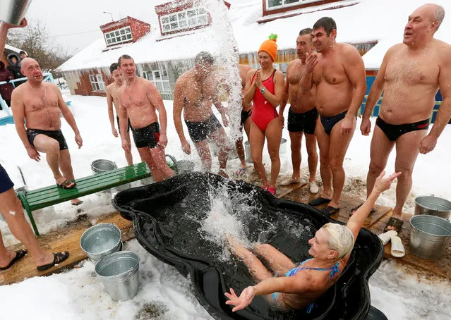 Members of a local winter swimmers club pour buckets of cold water onto each other during a celebration of Polar Bear Day at the Royev Ruchey zoo, with the air temperature at about minus 5 degrees Celsius (23 degrees Fahrenheit), in Krasnoyarsk, Russia, November 27, 2016. (Photo by Ilya Naymushin/Reuters)