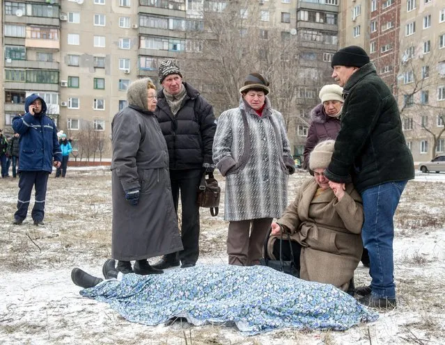 Relatives react beside the body of a victim after shelling in the eastern Ukrainian city of Kramotorsk on February 10, 2015. At least six civilians were killed and 21 wounded in a rocket attack on Ukraine's military headquarters in the war-torn east. (Photo by Volodymyr Shuvayev/AFP Photo)