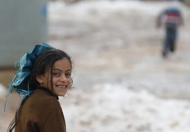 A Syrian girl Mariam from Raqqa looks on as she runs in snow in the Bekaa Valley in Lebanon after the first heavy snow storm hit Lebanon, January 3, 2016. (Photo by Jamal Saidi/Reuters)