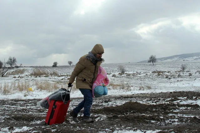 A migrant from Syria pulls a suitcase while walking in very cold weather, through snow from Macedonia to a camp for the temporary acceptance of migrants in the village Miratovac, on the border between Serbia and Macedonia, near to the south Serbian city of Presevo, 18 January 2016. Since the second half of November 2015, countries further along the Balkan route – Macedonia, Serbia, Croatia, Slovenia and Austria have stopped all so-called economic migrants and are allowing only Syrians, Afghans and Iraqis to pass. (Photo by Djordje Savic/EPA)