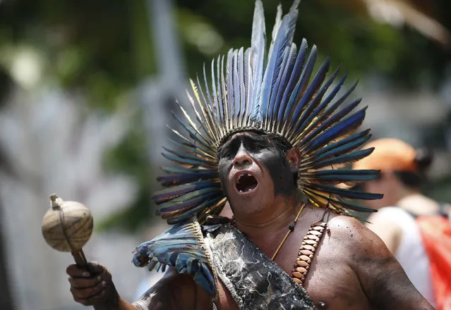 An indigenous man sings during a protest against austerity measures outside the state legislature, in Rio de Janeiro, Brazil, Monday, December 12, 2016. Police, firefighters and school teachers are among the workers from Brazil’s Rio de Janeiro state protesting against government austerity measures being considered by lawmakers. (Photo by Silvia Izquierdo/AP Photo)