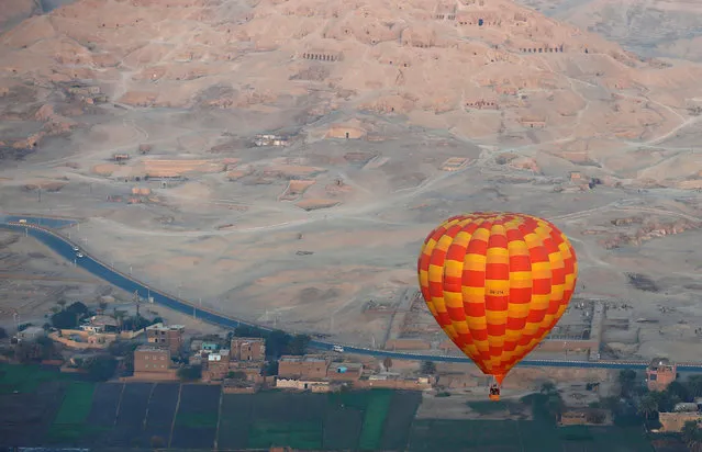A hot-air balloon flies over the village of al-Qurna, situated over a necropolis of more than 500 pharaonic tombs at the feet of the Theban Mountains, in the city of Luxor, south of Cairo, Egypt December 13, 2016. (Photo by Amr Abdallah Dalsh/Reuters)