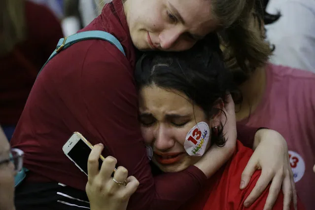 A supporter of Workers' Party presidential candidate Fernando Haddad embraces a fellow weeping supporter, after learning that rival Jair Bolsonaro was declared the winner in the presidential runoff election, in Sao Paulo, Brazil, Sunday, October 28, 2018. Addressing supporters in Sao Paulo, Haddad did not concede or even mention Bolsonaro by name. Instead, his speech was a promise to resist. (Photo by Nelson Antoine/AP Photo)