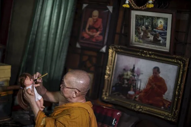 Buddhist monk Phra Winai Thidtapanyo, 64, anoints on a “child angel” doll during a blessing ritual at Wat Bua Khwan temple in Nonthaburi, Thailand, January 26, 2016. (Photo by Athit Perawongmetha/Reuters)