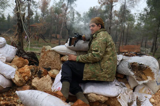 A rebel fighter rests with his weapon behind sandbags at insurgent-held al-Rashideen, Aleppo province, Syria December 30, 2016. (Photo by Ammar Abdullah/Reuters)