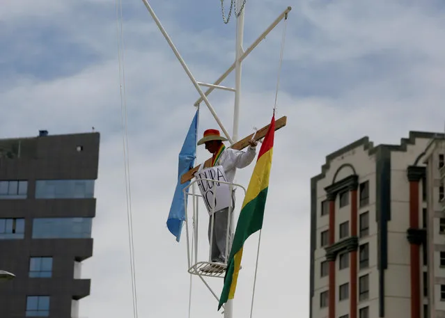 A demonstrator mock-crucifies himself at Eduardo Abaroa Square to protest against Bolivia's President Evo Morales bid for re-election in 2019, in La Paz, Bolivia December 6, 2018. (Photo by David Mercado/Reuters)