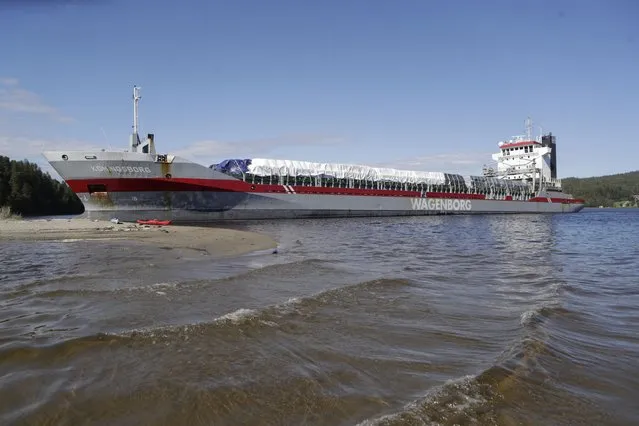 The Koningsborg, a 130 meter long cargo ship, run aground in the Angerman River in Sando, northern Sweden, Thursday, June 24, 2021. The incident happens Thursday morning when the Koningsborg, a vessel registered in the Netherlands and carrying timber destined for Casablanca in Morocco, suffered a technical failure and lost manoeuvrability. (Photo by Mats Andersson/TT News Agency via AP Photo)