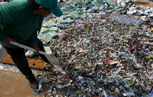 A Thai official arrange counterfeit watches before destroying them with a steamroller at Khlongluang Transportation Station in Pathumtani province, on the outskirts of Bangkok April 9, 2015. (Photo by Chaiwat Subprasom/Reuters)