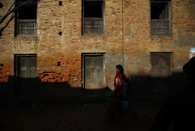 A woman walks past a house at Sankhu in Kathmandu January 28, 2015. (Photo by Navesh Chitrakar/Reuters)