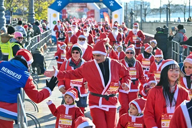 People in Santa Claus costumes take part in the traditional Christmas Santa Claus run on the banks of the River Danube in Budapest, Hungary, on December 3, 2023. The run took place in three categories - families with children, amateurs and professional runners. (Photo by Attila Kisbenedek/AFP Photo)