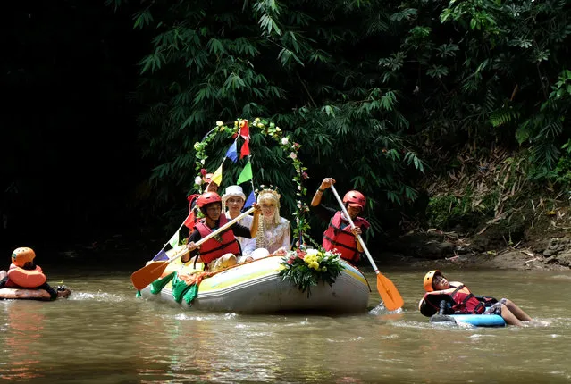 Novanto Rahman and his bride Sandra Fidelia Novianti, a volunteer who takes part in a Ciliwung river clean-up initiative, hold part of their wedding ceremony on the Ciliwung, which runs more than 100 km (60 miles) from its source in West Java to Jakarta bay, in Depok south of Jakarta, Indonesia December 18, 2016. (Photo by Adi Kurniawan/Reuters)