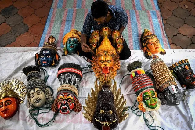An artisan prepares face masks resembling various Hindu deities for Kummattikali which is a form of colourful mask dance as a part of Onam festival celebrations in Kerala on August 18, 2021. (Photo by Arun Sankar/AFP Photo)