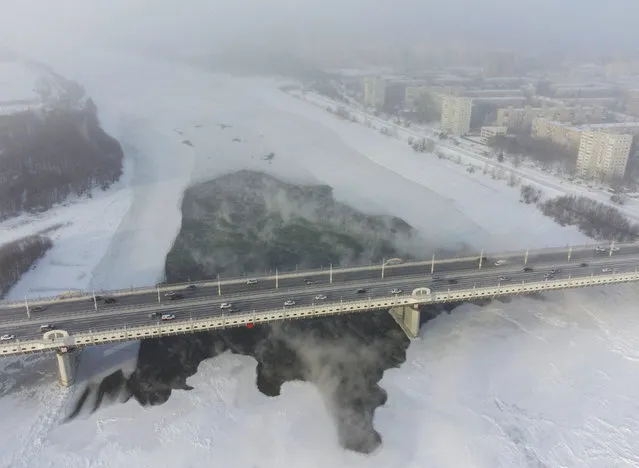 Cars drive on the bridge over the Irtysh River in Omsk, Russia on December 7, 2023. (Photo by Alexey Malgavko/Reuters)