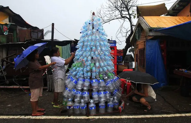 Victims of super Typhoon Haiyan decorate their improvised Christmas tree with empty cans and bottles at the ravaged town of Anibong, Tacloban city, central Philippines December 24, 2013, a month after Typhoon Haiyan battered central Philippines. (Photo by Romeo Ranoco/Reuters)