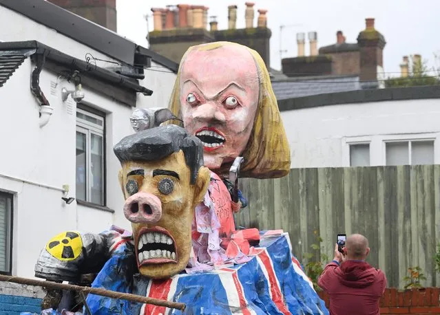A man records imagery of an effigy depicting British Prime Minister Rishi Sunak and former British Prime Minister Liz Truss ahead of it being paraded through the town during the annual Bonfire Night festivities in Lewes, Britain on November 5, 2022. (Photo by Toby Melville/Reuters)