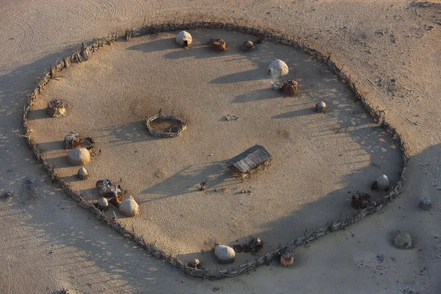 An aerial view of a livestock enclosure of the Himba people, in October, 2014, in the Namib Desert, Namibia. (Photo by Theo Allofs/Barcroft Media)