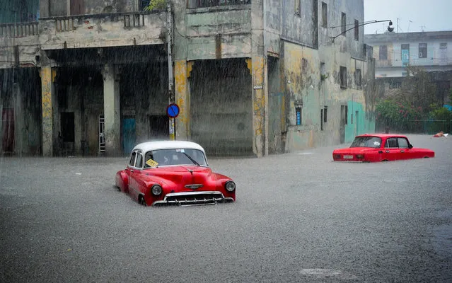 Stranded cars remain in a flooded street during an intense rainstorm in Havana, on April 29, 2015.  Two people were killed, three buildings collapsed and another 24 suffered some kind of damage due to the heavy rain that affected several sectors of Havana Wednesday. (Photo by Yamil Lage/AFP Photo)