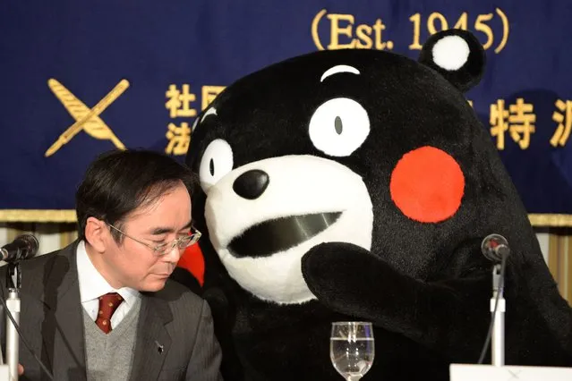 Kumamon gestures to brand officer for the Kumamoto prefecture government, Masataka Naruo (L) during a press conference at the foreign correspondents' club in Tokyo on February 15, 2014. (Photo by Toshifumi Kitamura/AFP Photo)