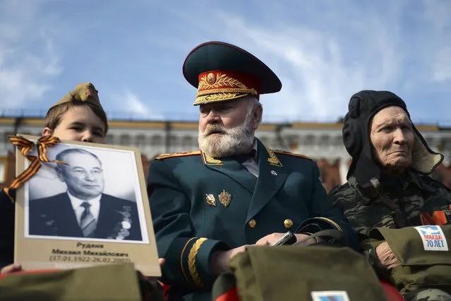 Veterans and a boy wait for the Victory Day parade at Red Square in Moscow, Russia, May 9, 2015. (Photo by Reuters/Host Photo Agency/RIA Novosti)