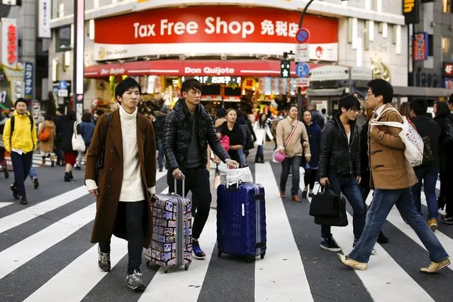 People cross a street outside a tax free department store popular among Chinese tourists in Tokyo, Japan, February 11, 2016. (Photo by Thomas Peter/Reuters)