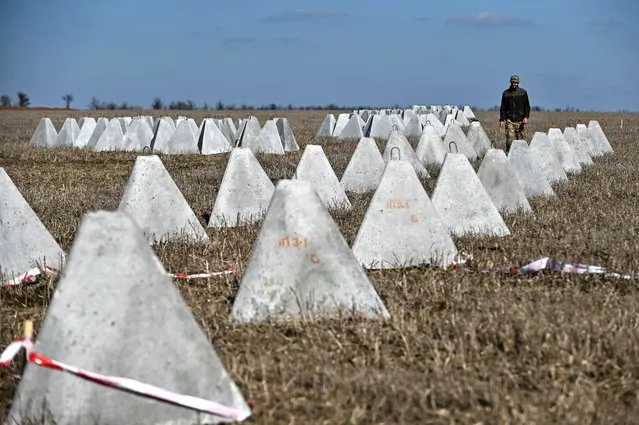 Danylo, commander of an engineering and sapper company of the Ukrainian Armed Forces, inspects pyramidal anti-tank obstacles known as 'dragon's teeth' before installing them into a new fortification line, amid Russia's attack on Ukraine, in Zaporizhzhia region, Ukraine on March 11, 2024. (Photo by Reuters/Stringer)